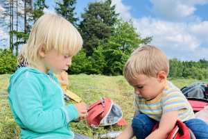 Děti svačí na louce.